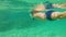 4k underwater shot of a cute little boy snorkeling with a mask and tube in a tropical sea with lots of tropical fishes