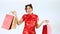 4K video Asian woman in red traditional oriental costume holding shopping bags. Chinese new year in shopping concept style.