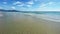 4k video. Calm soft sea waves, on the shore of a sandy beach, view of an empty long beach without people