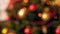 4k video of camera slowly focusing on deocrated Christmas tree with colorful lights and garlands. Perfect abstract shot