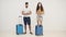 4k video of couple with blue suitcases standing together.