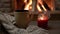 4K video. Cozy fireplace and a cup of tea and a candle.