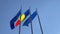 4K Video. Flags of Romania, European Union and NATO winding over a blue sky background.