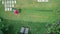 4k video footage of a man mowing the lawn. Aerial view.