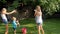 4k video of of happy young family splashing and pouring water over each other at hot sunny day on grass at backyard