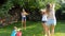 4k video of laughing happy family having water battle on grass at backyard.