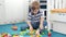 4k video of little 4 years old boy playing with toys on floor at his room. Child building and assembling with colorful