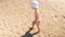 4k video of little barefoot toddler boy feeling hot sand on sea beach at sunny day