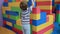 4k video of little boy building high tower from big colorful blocks on playground at shopping mall