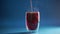 4k video pouring mulled red wine in double glass cup on blue background. Alcohol punch Drink with orange, anise star