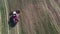 4k video of red tractor top view harvesting cereals