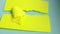 4k video, small pieces of yellow paper falling on a torn paper banner lying on a blue cardboard background, a copy of