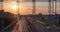 A 4K video time lapse of the highway at sunset shot from the overpass behind the road safety wire fence.