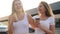 4k video of two smiling and laughing female friends having good time and drinking coffee while walking on street at