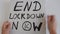 4k video of woman holding protest poster with words `End Lockdown Now`.