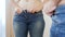 4k video of young woman getting dressed and struggling putting on small jeans. Concept of overweight