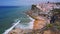 4K view of the picturesque village Azenhas do Mar. Chalk buildings on the edge of a cliff and beach below with white