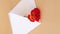 4k zoom in out vertical Beautiful red roses flowers in postal envelope on neutral beige background, copy space for text