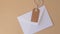4k zoom in out White envelope with beige paper note and rope in heart shape on neutral beige background. Greeting card