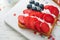 4th of July American Independence Day food. American flag sandwich with strawberries, blueberries, whipped sweet cream, soft