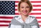 4th of July. Smiling young woman on United States flag background.