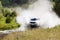 A 4wd car overcomes a water obstacle at high speed surrounded by spray