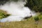 A 4wd car overcomes a water obstacle at high speed surrounded by spray