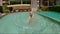 4x times slowmotion shot of a little boy splashing water in a pool