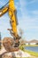 A 4x4 backhoe loader, with a bucket filled with dirt