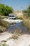 4x4 safari car crossing water with unknown depth in a hot day. Off-road tour moremi national park, okovango river delta