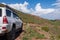 4x4 SUV on dangerous off-road mountain trail background. Offroad journey, travel. Summer travel concept. Mountain road