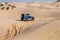 4X4 vehicle drives around the sand dunes of the Sahara Desert.