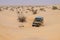 4X4 vehicle drives around the sand dunes of the Sahara Desert.