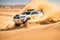4x4 vehicle rides through the desert dunes in the evening sun, rally offroad car, generative ai