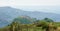 4x4 vehicle in rolling fertile hills with fields and crops on Ring Road of Cameroon, Africa