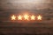 5 golden stars on a wooden background, assignment of a new rating, service rating, a new level, business concept. Mixed medium