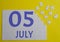 5 july calendar date on a white puzzle with separate details. Puzzle on a yellow background with a blue inscription