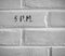 5 P.M. WRITTEN ON WHITE PLAIN BRICK WALL