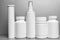 5 white vials without labels for medicines, vitamins, sprays, liquids are on a gray shelf.