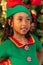 5-year-old Afro-Colombian Colombian Latino girl dressed as an elf next to the Christmas tree