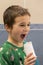 A 5-year-old boy at home washes his teeth with an oral irrigator. Little boy cleaning teeth with oral irrigator. Dental Care