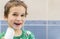 A 5-year-old boy at home washes his teeth with an oral irrigator. Little boy cleaning teeth with oral irrigator. Dental Care