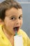A 5-year-old boy at home washes his teeth with an oral irrigator. Little boy cleaning teeth with oral irrigator. Dental Care