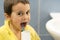 A 5-year-old boy at home washes his teeth with an oral irrigator. Little boy cleaning teeth with oral irrigator. Dental Care