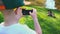 5 year old boy photographed on a mobile phone black swan sitting on the grass near the pond