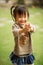 5 year old Chinese Asian girl in a garden making faces