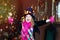 5 years old girl in clown costume with wide smile near christmas tree. Happiness and masquerade in christmas time. Happy child in