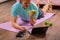 50 year old man performs exercises lying on mat at home looking at computer