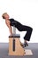 A 50-year-old trainer practices Pilates on an elevator chair, bending into a bridge position