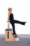 A 50-year-old trainer is practicing Pilates on a machine. She stands on her toes and holds herself with her hands. She